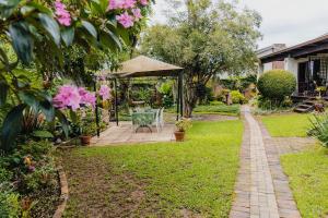 a garden with a gazebo and a table and chairs at Rustic Butler B&B in White River
