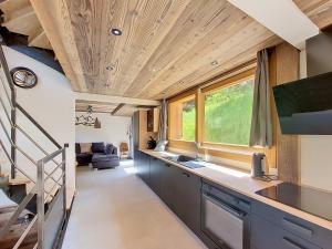 a kitchen and living room with wooden ceilings at Gervonne 2 in Morzine