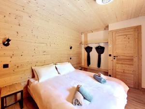 a bedroom with a large white bed with wooden walls at Gervonne 2 in Morzine