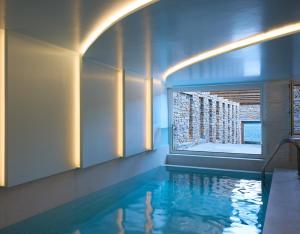 a swimming pool with a window in a building at Ydor Hotel & Spa by Sandglass in Vourkari