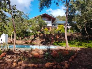 a house with a swimming pool in front of a house at Bushwillows B&B in Rustenburg