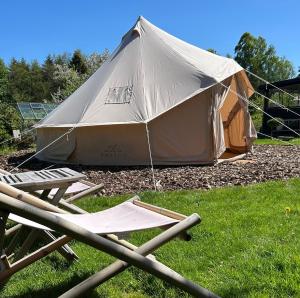 a large tent with a table and chairs in the grass at Cozy Garden Glamping in Svendborg