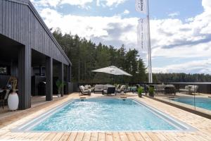 a pool on a deck with chairs and an umbrella at Pellinge Marina in Porvoo