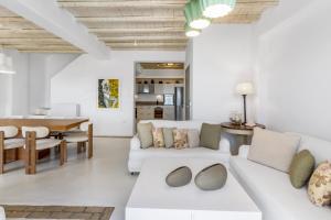 a living room with a white couch and a table at Your private Mykonos Villa in Kalafatis