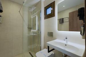 a white bathroom with a sink and a shower at Sunset Hotel in Ouranoupoli +146 photos
