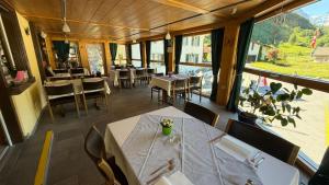 a restaurant with tables and chairs and a large window at Adler in Linthal