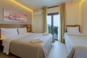 a hotel room with two beds and a balcony at Sunset Hotel in Ouranoupoli