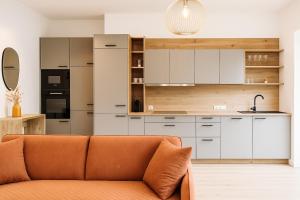 a living room with a couch in front of a kitchen at Rauchhof in Auer