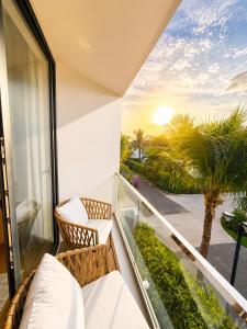 a balcony with a view of the sunset at Sea La Vie Beachfront Villa - Bai Truong Beach Phu Quoc in Phú Quốc