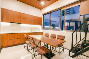 a kitchen and dining room with a wooden table and chairs at Sunset Samson Hotel in Sầm Sơn