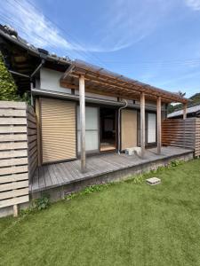 a house with a wooden deck and a yard at 和風アンドラン in Minamiawaji