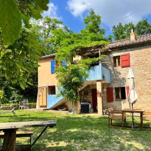 a house with a picnic table and an umbrella at The Bookhouse Home Bb in Poggio San Marcello 