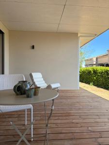 a patio with a table and chairs on a wooden floor at Villa Loka-Ecrin contemporain Adult only in Sauzet