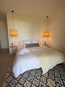 a bedroom with a large white bed with two lights at Villa Loka-Ecrin contemporain Adult only in Sauzet
