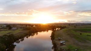 a view of a river with the sun setting at Oscars Retreat 1 by Tiny Away in Raworth