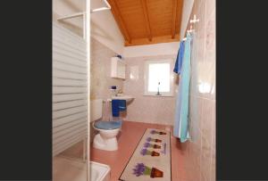 a bathroom with a toilet and a sink and a window at Casa Esmeralda in San Nazzaro