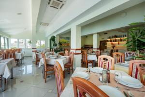 a restaurant with white tables and wooden chairs at Hotel Adria in Neum