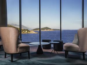 a room with chairs and a table and a view of the ocean at Rixos Premium Dubrovnik in Dubrovnik
