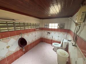 ein Badezimmer mit zwei Toiletten und einem Urinal in der Unterkunft SP Home at Maesot in Mae Sot + 14 Fotos