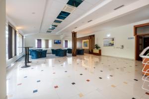 a large lobby with couches and tables on a tile floor at Hotel Adria in Neum