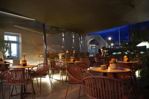 ein Restaurant mit Holztischen und Stühlen am Abend in der Unterkunft Hotel Santorini in Fira