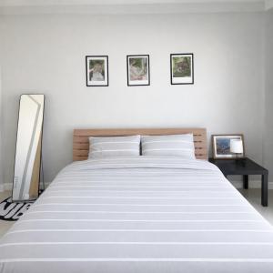 a bedroom with a white bed with three pictures on the wall at Mayeen cat hotel in Chiang Mai