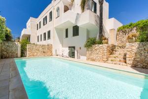 a villa with a swimming pool in front of a building at Residence Quattro Colonne in Santa Maria al Bagno