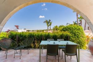 a table and chairs on a patio with an archway at Residence Quattro Colonne in Santa Maria al Bagno