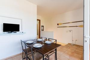 a dining room with a table with chairs and a tv at Residence Quattro Colonne in Santa Maria al Bagno