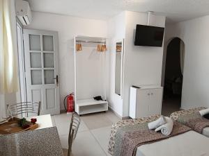 a white room with two beds and a television at NIKOLAS HOUSE CLOSE To TOWN in Mikonos