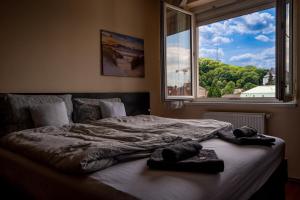 a bed in a bedroom with a large window at Rooftop Apartments in Miskolc