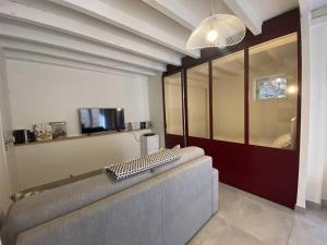 a living room with a gray couch in a room at Le réveil des oiseaux in Taillet