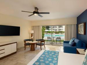 a living room with a blue couch and a tv at Impressive Premium Punta Cana - All Inclusive in Punta Cana