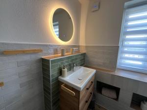 a bathroom with a sink and a mirror at Haus Wally - Ferienwohnungen in Klitten