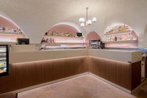 a bar in a restaurant with pink walls at Hotel Centrale in Nago-Torbole