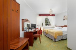 a hotel room with a bed and a desk and a bed at Chimera Spa Niechorze in Niechorze