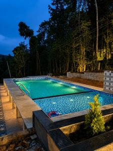 a swimming pool in a backyard at night at Sunset Villa by Hyatt Stay in Avathi
