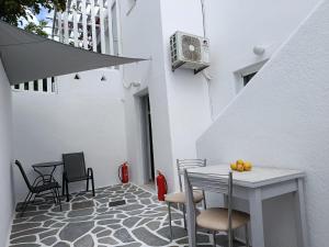 a patio with a table and chairs on a floor at NIKOLAS HOUSE CLOSE To TOWN in Mikonos