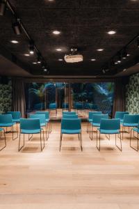 a waiting room with blue chairs and tables at Uma House by Yurbban Trafalgar in Barcelona +82 photos