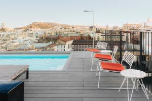 a balcony with tables and chairs and a swimming pool at Uma House by Yurbban Trafalgar in Barcelona