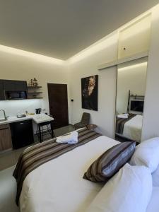 a hotel room with a large bed and a kitchen at Railway Studio 2 - Modern Studio in Byblos - Easy city Access in Jbeil