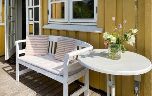 a table and chairs on a porch with a vase of flowers at 3 Bedroom Beautiful Home In Bryrup in Bryrup
