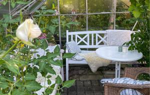 a garden with a white chair and a table in a greenhouse at 3 Bedroom Beautiful Home In Bryrup in Bryrup +12 photos