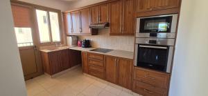 a kitchen with wooden cabinets and a stove top oven at Nautical Nest in Livadhia