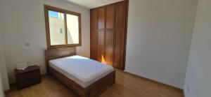 a small bedroom with a bed and a window at Nautical Nest in Livadhia