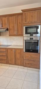 a kitchen with wooden cabinets and a stove top oven at Nautical Nest in Livadhia +5 photos