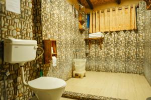 a bathroom with a toilet and a sink at Camp Hornbill Corbett in Rāmnagar +130 photos