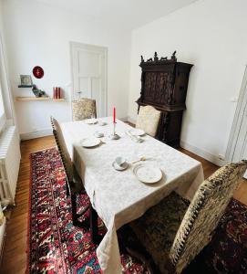 a dining room with a table with chairs and a candle at Le boudoir de Marie in Montluçon