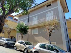 two cars parked in front of a building at Sole & Mare in Palmi