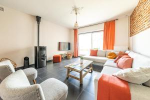 a living room with a couch and chairs and a tv at Gîte Athois la campagne in Ath